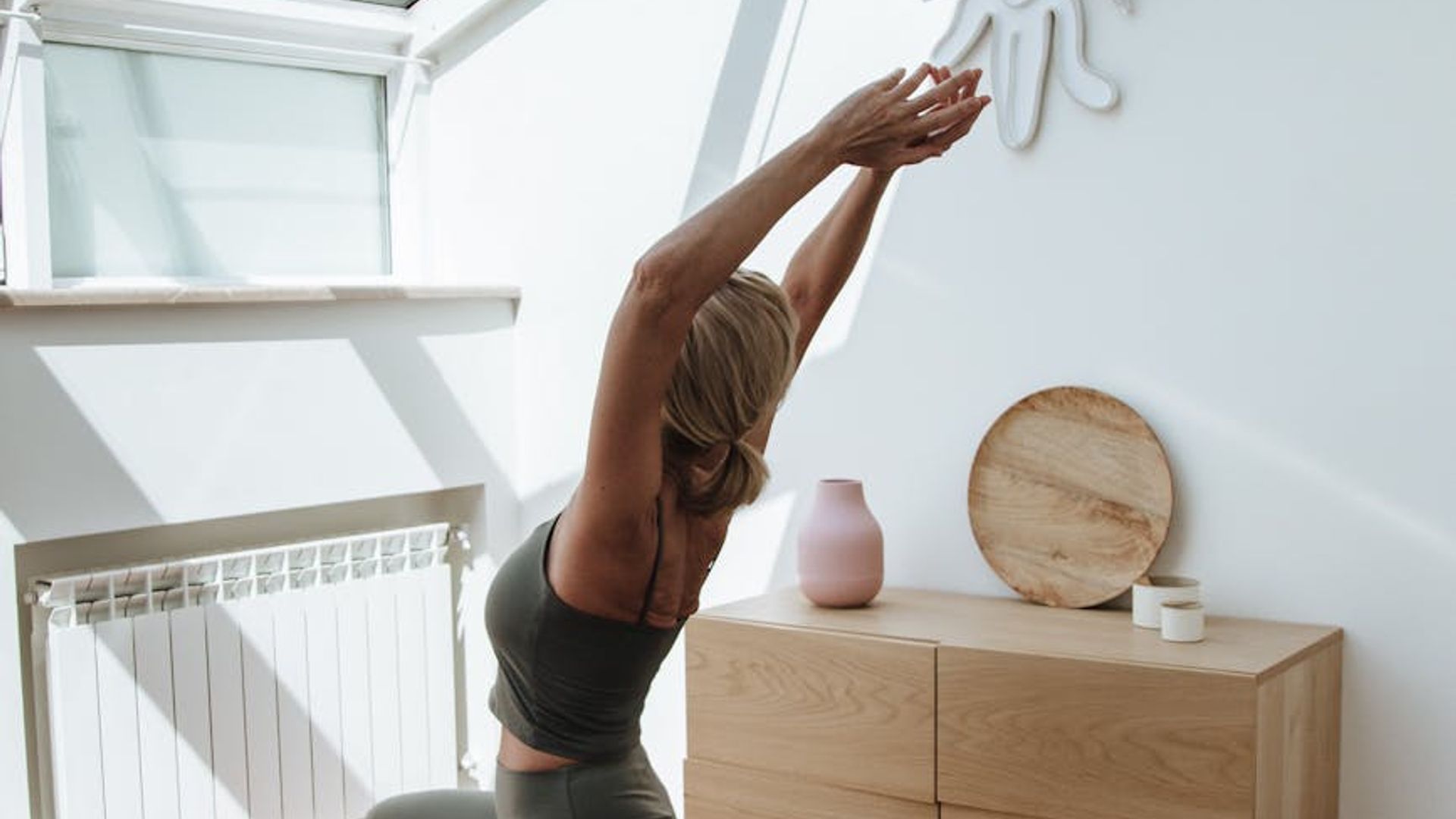 Person doing yoga in a bright room with sunlight